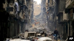 FILE - Residents walk through the destruction of the once rebel-held Salaheddine neighborhood in the eastern Aleppo, Syria, Jan. 20, 2017. The United Nations said the first 10 years of Syria's conflict, which began in 2011, killed more than 300,000 civilians. 