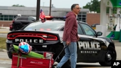 A man carries his belongings after a mass shooting at a Fourth of July parade in Highland Park, Illinois, a Chicago suburb on July 4, 2022.