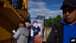 A man shows a portrait of Wilmer Tulul, in Tzucubal, Guatemala, June 29, 2022. Wilmer and his cousin were among the dead discovered inside a semitrailer on the edge of San Antonio, Texas, on June 27, in a deadly case of human smuggling.