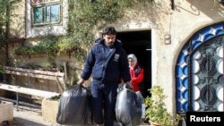 A charity's volunteer carries bags of humanitarian aid to be distributed to people in need, in Damascus, Syria, Jan. 30, 2022.