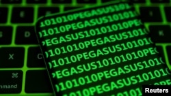FILE - The word Pegasus and binary code are displayed on a smartphone placed on a keyboard in this illustration photo taken May 4, 2022. Pegasus from Israel’s NSO Group is perhaps the best-known example of commercial spyware, according to security researchers.
