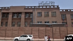 FILE - Afghan men walk past Da Afghanistan Bank in Kabul on June 28, 2011. 