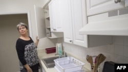 FILE - A volunteer from a local church looks at the kitchen cabinets in a church-sponsored apartment that was going to be the home for Syrian refugees, in Alexandria, Virginia, Feb.1, 2017. 