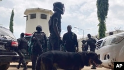 Officers stand guard outside the Kuje maximum prison following a rebel attack in Kuje, Nigeria, July 6, 2022. 