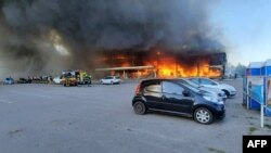 This handout picture taken and released by the Ukraine's State Emergency Service on June 27, 2022 shows firefighters putting out the fire in a mall hit by a Russian missile strike in Kremenchuk, killing at least two and injuring dozens more.
