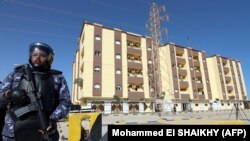 ARCHIVES - Un agent de sécurité montent la garde devant le bâtiment du Parlement libyen à Tobrouk, le 15 mars 2021.