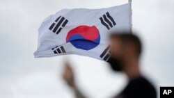 A visitor uses a smartphone to film at the unification observatory in Paju, South Korea, July 7, 2022. 