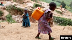FILE - A girl carries a container of water at a coltan mine in Kamatare, Masisi territory, North Kivu Province of Democratic Republic of Congo, December 1, 2018. (REUTERS/Goran Tomasevic/File Photo)