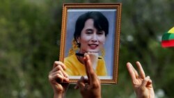 FILE - A person holds a picture of leader Aung San Suu Kyi as Myanmar citizens protest against the military coup in front of the UN office in Bangkok, Thailand Feb. 22, 2021.