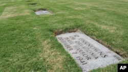 FILE - A gravestone marking 12 sets of unidentified remains from the USS Oklahoma buried at the National Memorial Cemetery of the Pacific in Honolulu.