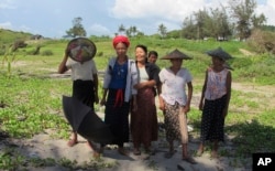 FILE - Women gather to make offerings to spirits near a beach in Kyaukpyu on the Bay of Bengal that may become a resort area in the Rakhine region of Myanmar, Oct. 5, 2016.