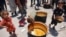 A child picks food from the bottom of a pot at a U.N. Relief and Works Agency for Palestine Refugees school in the Jabalia camp for Palestinian refugees in the northern Gaza Strip on June 17, 2024.