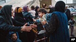 FILE - Displaced civilians line up outside a tent set up by MSF, or Doctors Without Borders, to receive medical aid, in Makhmour, east of Mosul, Iraq, March 28, 2016. Woman and children are the most heavily traumatized, aid workers say.