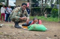 New volunteer Mekdess Muluneh Asayehegn, right, and others receive training to become potential reinforcements for pro-government militias or military forces, in a school courtyard in Gondar, in the Amhara region of northern Ethiopia Aug. 24, 2021.