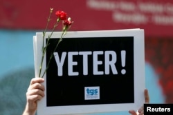 A member of the Journalists Union of Turkey holds a placard reading "Enough!" during a demonstration to mark World Press Freedom Day in central Istanbul, May 3, 2017.