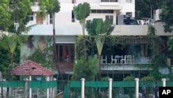 FILE - Bangladeshi policemen walk past the Holey Artisan Bakery, the site of a militant attack, in Dhaka's Gulshan area, Bangladesh. 