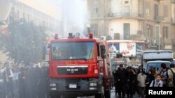 Egyptian riot police fire a water cannon to disperse people protesting against a new law restricting demonstrations, in downtown Cairo, Nov. 26, 2013. 