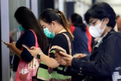 Para penumpang perempuan mengenakan masker menunggu MRT, di Jakarta, 4 Maret 2020. (Foto: Reuters)