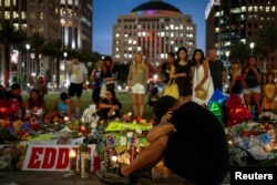 FILE - Mourners gather at a makeshift memorial in downtown Orlando for victims of the gay nightclub shooting, in Orlando, Florida, June 14, 2016.