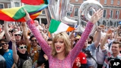 FILE- Rory O'Neill, known by the Drag persona Panti, celebrates the referendum result with "yes" supporters at Dublin Castle, Ireland, May 23, 2015. 