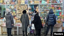 俄羅斯西伯利亞城市鄂木斯克的顧客在一個攤位外排隊等待購買食物。 （2024年11月29日）