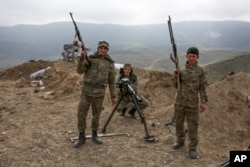 FILE - Armenian soldiers pose near a frontline in Nagorno-Karabakh, Azerbaijan, April 6, 2016.