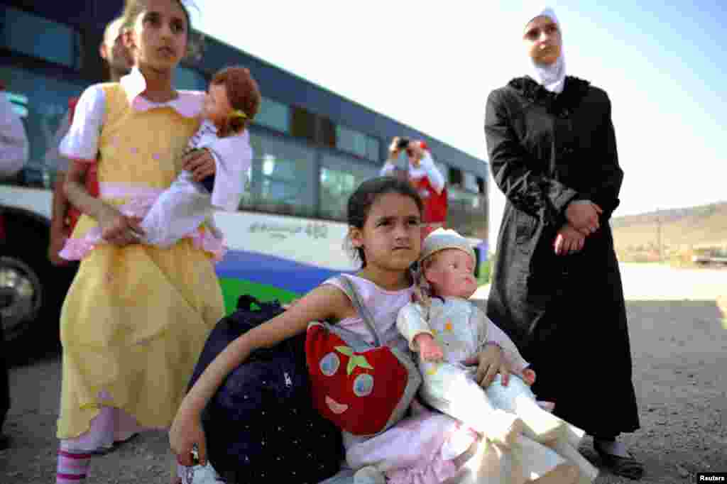Girls that were evacuated from the besieged Damascus suburb of Daraya after an agreement was reached between rebels and Syria&#39;s army, arrive to a camp inside the government-controlled Herjalleh suburb of Damascus, Aug. 27, 2016.
