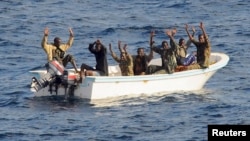 Suspected pirates keep their hands in the air as directed by sailors aboard the guided-missile cruiser USS Vella Gulf (CG 72) (not shown), in the Gulf of Aden, February 11, 2009.
