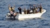 Suspected pirates keep their hands in the air as directed by sailors aboard the guided-missile cruiser USS Vella Gulf (CG 72) (not shown), in the Gulf of Aden, February 11, 2009.