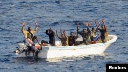 Suspected pirates keep their hands in the air as directed by sailors aboard the guided-missile cruiser USS Vella Gulf (CG 72) (not shown), in the Gulf of Aden, February 11, 2009.