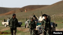 FILE - Afghan National Army soldiers (ANA) check the road before an operation at the Mir Abadi village of Adraskan district of Herat province, April 4, 2014. 