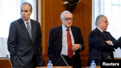 Lakhdar Brahimi (C), the U.N. envoy on Syria, waits with other delegates before a meeting at the United Nations European headquarters in Geneva, Switzerland, Dec. 20, 2013. 