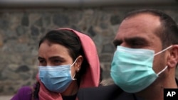 Afghan journalists wear face masks during a coverage of a campaign to raise awareness of the new coronavirus in Kabul, Afghanistan, March 16, 2020.