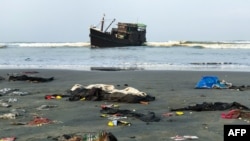Belongings of Rohingya refugees lay on the shore as their carrier boat remains anchored nearby in Teknaf on 16 April 2020.