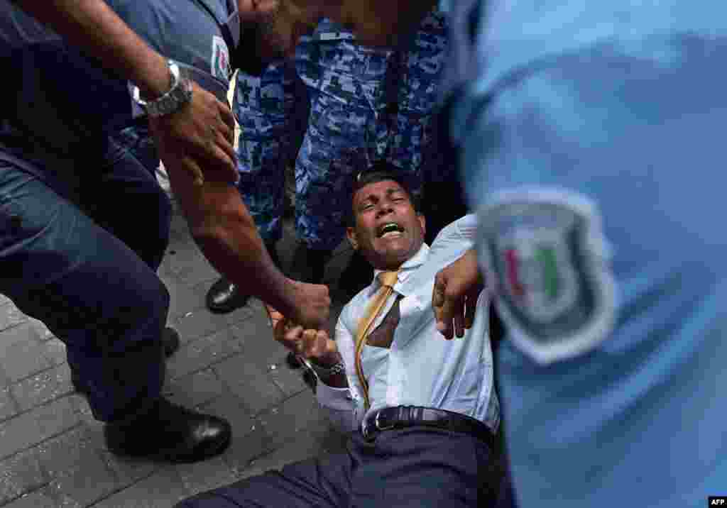 Maldives police try to move former President Mohamed Nasheed during a scuffle as he arrives at a courthouse in Male, Feb. 23, 2015. A court in the Maldives will decide whether to grant bail to former president, a day after his surprise arrest on terrorism charges.