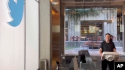 This image from the Twitter page of Elon Musk shows Musk entering Twitter headquarters carrying a sink through the lobby area, Oct. 26, 2022 in San Francisco. 