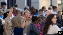 Family and friends wait to greet staff of the Navy Yard as they are bused to Nationals Park, in Washington, Sept. 16, 2013.