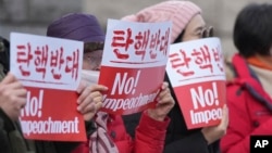 Supporters of impeached South Korean President Yoon Suk Yeol hold signs during a rally to oppose his impeachment outside the Constitutional Court in Seoul, South Korea, Jan. 14, 2025