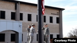 FILE - Members of a flag detail lower the flag in front of the Norma Brown Building on Goodfellow Air Force Base, Texas, March 16, 2018. (Airman 1st Class S. Hines / USAF)