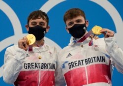 Thomas Daley and Matty Lee of Britain pose for a photo after winning gold medals during the men's synchronized 10m platform diving final at the Tokyo Aquatics Center at the 2020 Summer Olympics, July 26, 2021, in Tokyo, Japan.