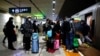 People wait with luggage to board a train at a railway station, amid the COVID-19 outbreak, in Wuhan, Hubei province, China Jan. 1, 2023. 