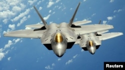 Two U.S. Air Force F-22 Raptor stealth jet fighters fly near Andersen Air Force Base in this handout photo dated Aug. 4, 2010. 