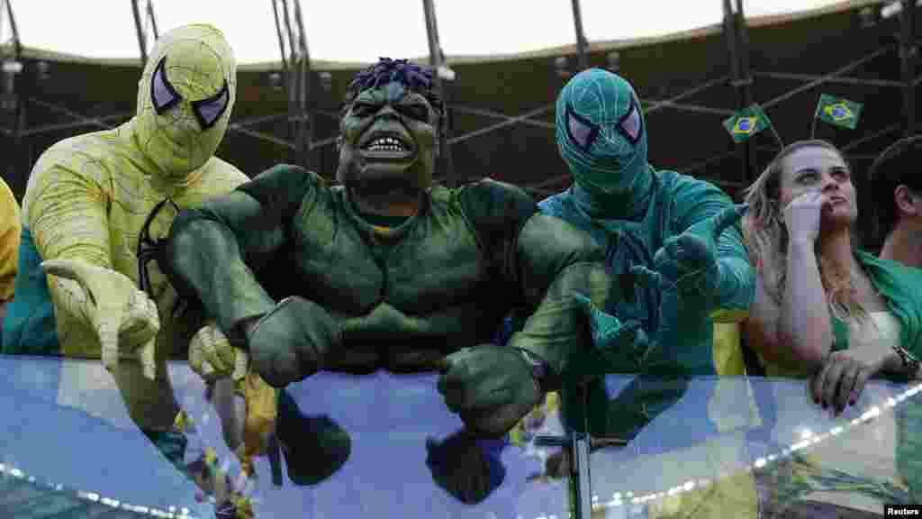 Fans dressed as superheroes await the start of the match between Brazil and Chile at the Mineirao stadium in Belo Horizonte, June 28, 2014.
