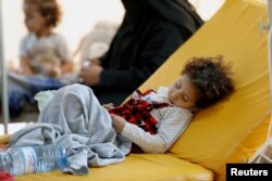 FILE - A girl sleeps on a bed at a cholera treatment center in Sanaa, Yemen, Aug. 4, 2018.