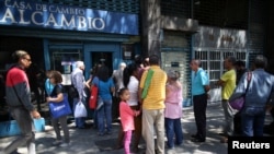 People wait in line outside of a currency exchange house in Caracas, Venezuela, Feb. 5, 2019.