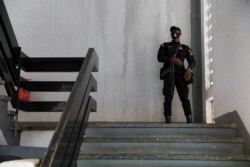 FILE - A police officer stands guard before the bail hearing of 21 people who were detained by police and accused of unlawful assembly and promoting an LGBTQ agenda, in Ho, Volta region, Ghana, June 4, 2021.