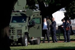 Attorney General William Barr, center, stands in Lafayette Park across from the White House as demonstrators gather to protest the death of George Floyd, June 1, 2020, in Washington.