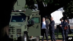 FILE - Attorney General William Barr, center, stands in Lafayette Park across from the White House as demonstrators gather to protest the death of George Floyd, June 1, 2020, in Washington. Floyd died after being restrained by Minneapolis police officers.