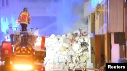 A firefighter stands on a fire truck after a building collapsed in Marseille, France, April 9, 2023, in this screengrab obtained from a social media video. BFMTV/via REUTERS