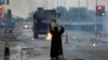 FILE - A female protester holds a photo of Shi'ite scholar Isa Qassim as she confronts riot police armoured personnel carrier during a demonstration to mark the 6th anniversary of the February 14 uprising, in the village of Sitra, south of Manama.